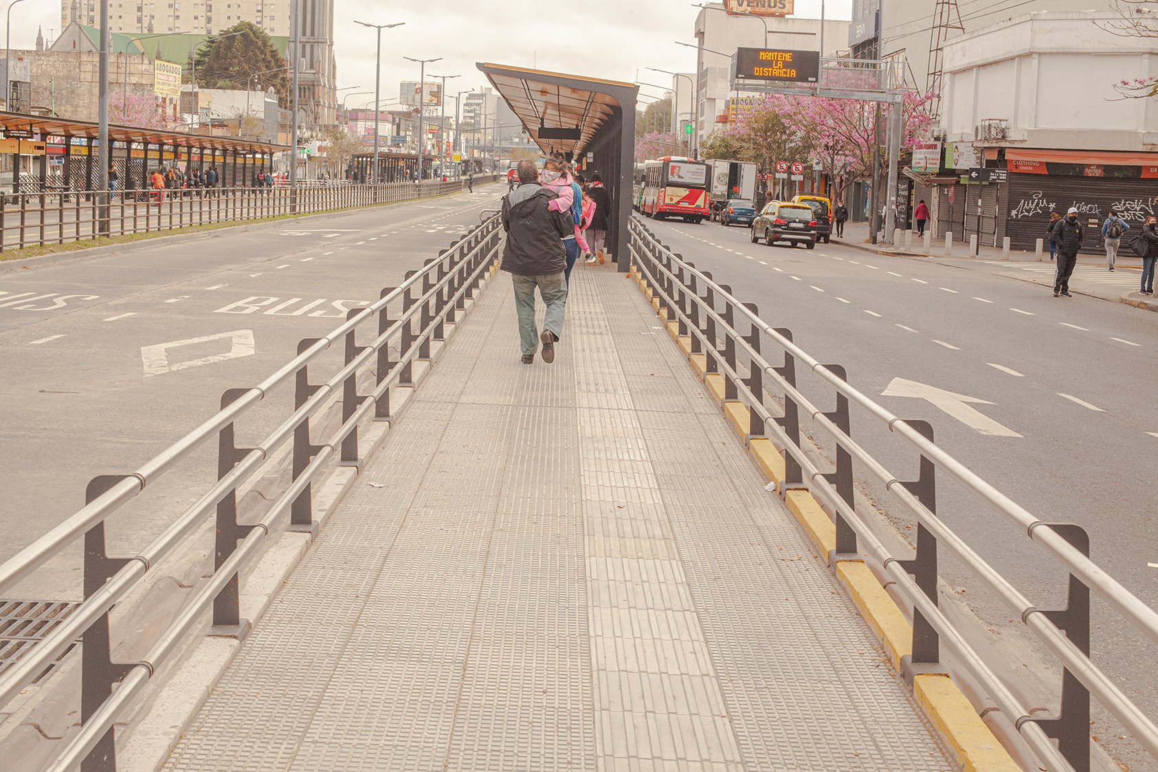 Pedestrians walking on central crossing island on large avenue